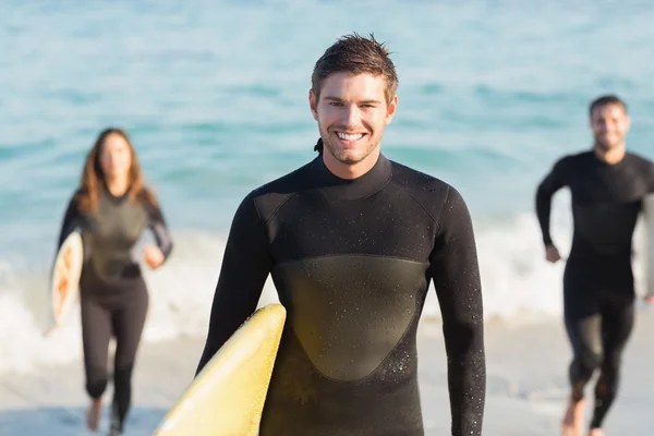 Friends on wetsuits with surfboard at beach — Stock Photo, Image