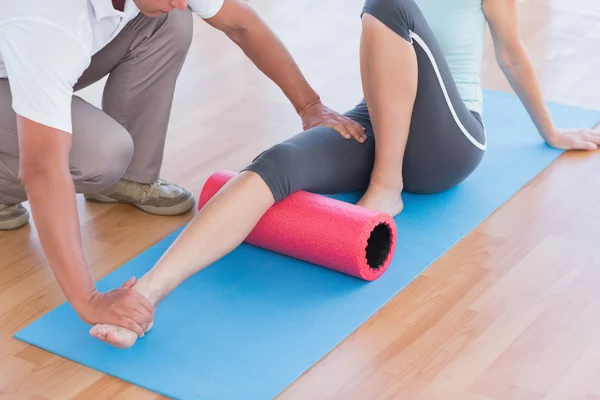 Trainer working with woman on exercise mat — Stock Photo, Image