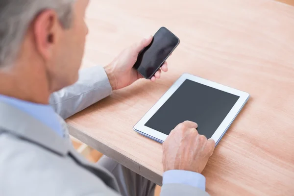 Businessman holding tablet and smartphone — Stock Photo, Image