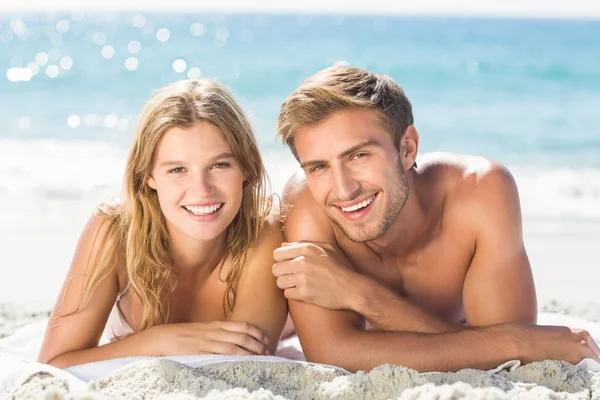 Casal feliz relaxando juntos na areia — Fotografia de Stock