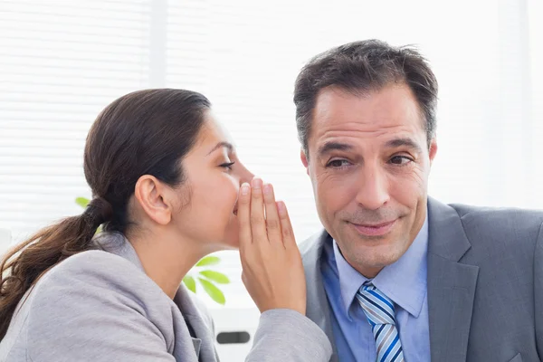 Businesswoman whispering something to colleague — Stock Photo, Image
