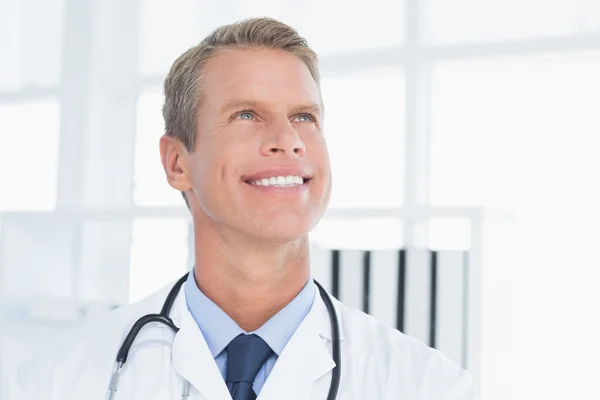 Médico sorridente olhando para cima — Fotografia de Stock