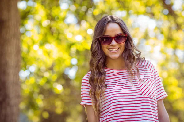 Mooie brunette glimlachend in het park — Stockfoto