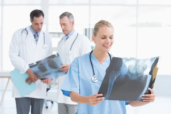 Médico sonriente mirando rayos X — Foto de Stock