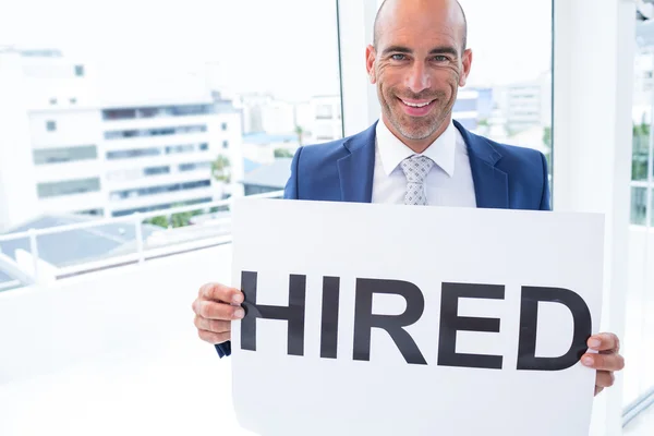 Businessman holding a hired sign — Stock Photo, Image