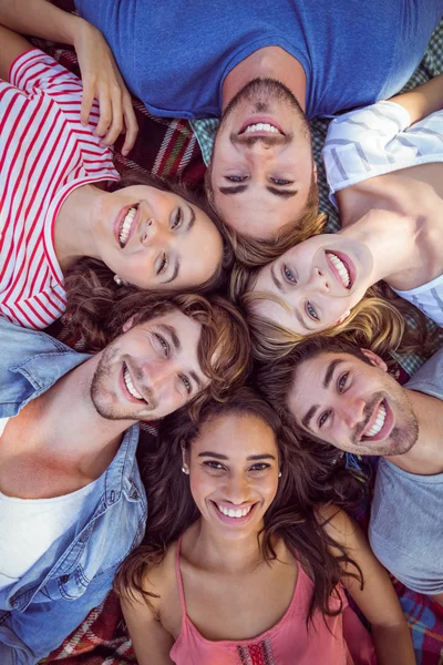 Amigos felizes em um parque que se agacha no círculo — Fotografia de Stock