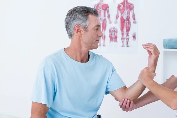 Doctor examining her patient arm — Stock Photo, Image