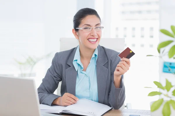 Mujer de negocios sonriente sosteniendo su tarjeta de crédito — Foto de Stock