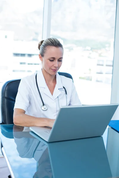 Médecin souriant tapant sur le clavier — Photo