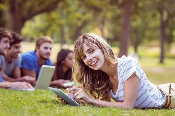 Vackra blonda med hjälp av Tablet PC i parken — Stockfoto