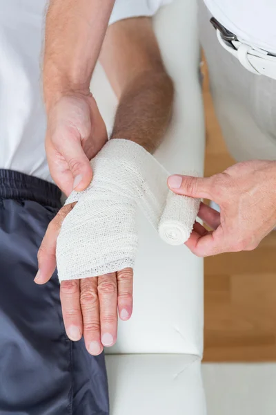 Doctor vendando su mano paciente — Foto de Stock