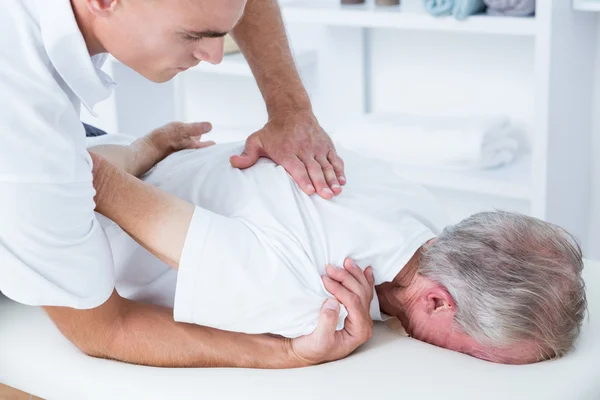 Fisioterapeuta fazendo massagem no ombro para seu paciente — Fotografia de Stock