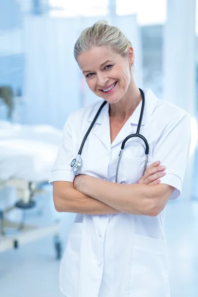 Sorridente medico in piedi braccia incrociate — Foto Stock