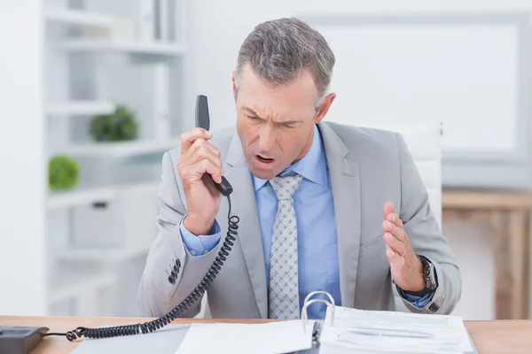 Irritated businessman answering phone — Stok fotoğraf
