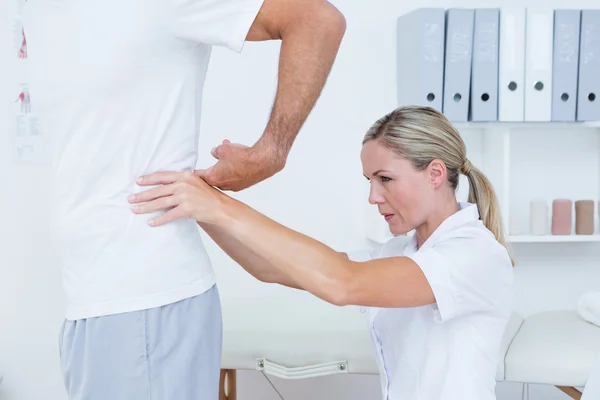 Doctor examining her patient back — Stock Photo, Image