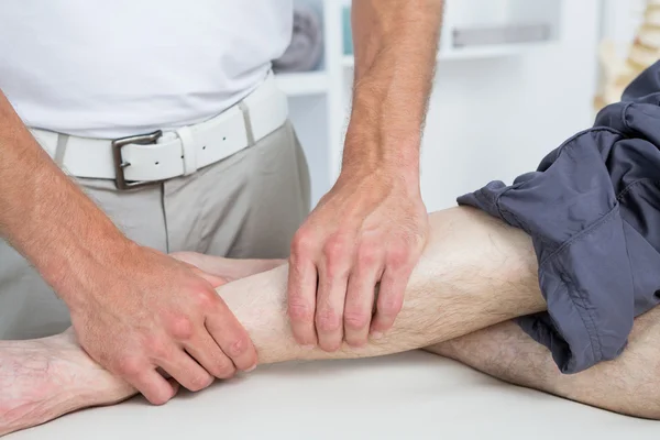 Physiotherapeut macht Beinmassage für seinen Patienten — Stockfoto