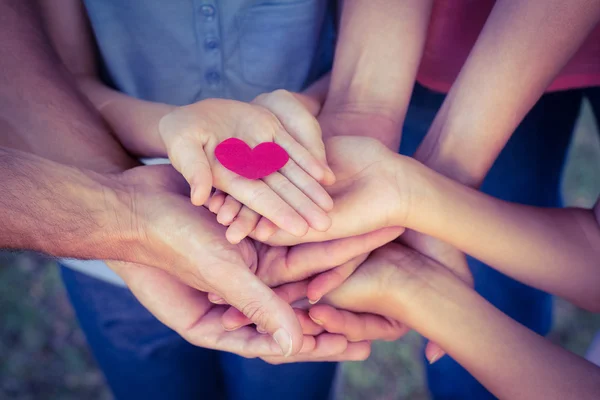 Famiglia felice nel parco con un cuore in mano — Foto Stock