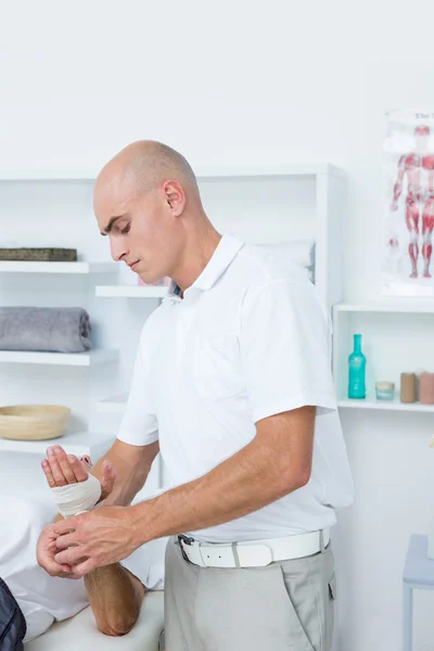 Doctor bandaging his patient hand — Stock Photo, Image