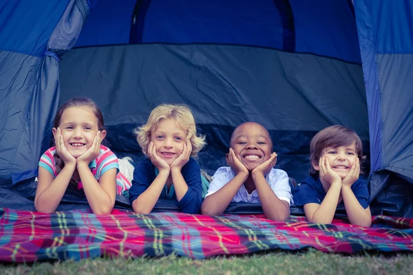 Mosolygó gyerekek együtt fekszenek a sátorban. — Stock Fotó