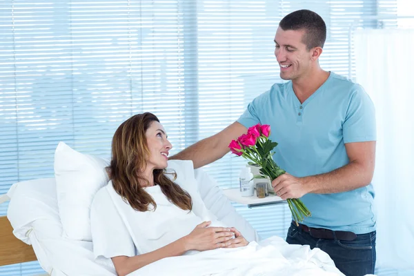 妊娠中の妻に花を提供している男 — ストック写真