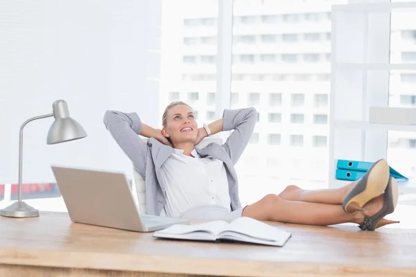 Lächelnde Geschäftsfrau entspannt sich in ihrem Büro — Stockfoto