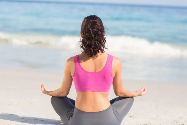 Wear view of fit woman doing yoga beside the sea — Zdjęcie stockowe