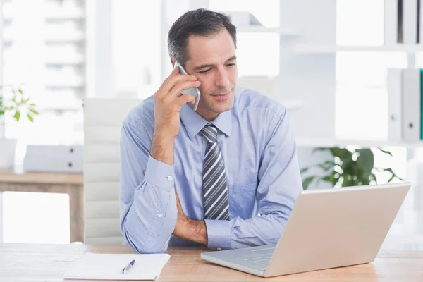 Empresário telefonando em sua mesa — Fotografia de Stock