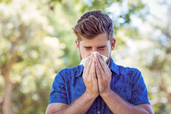 Knappe hipster zijn neus waait — Stockfoto