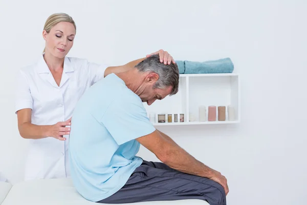 Doctor estirando a un hombre hacia atrás —  Fotos de Stock