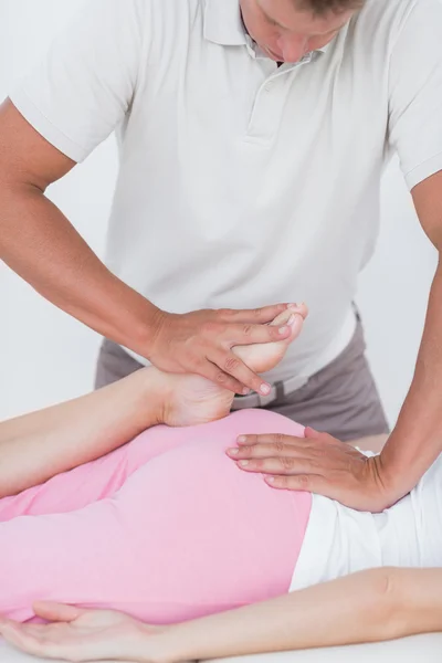 Fisioterapeuta haciendo masaje de piernas a su paciente — Foto de Stock