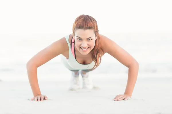 Beautiful brunette doing push ups — Stockfoto