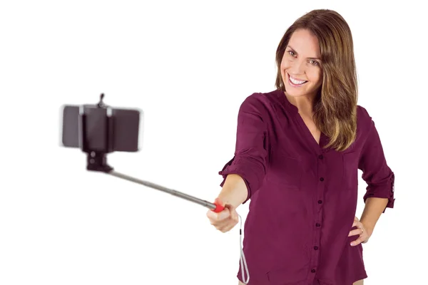 Pretty woman using a selfie stick — Stock Photo, Image