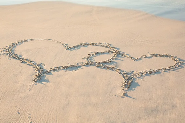 Två hjärtan dras i sanden — Stockfoto