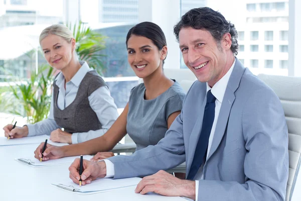 Lächelnde Gruppe von Geschäftsleuten, die Notizen machen — Stockfoto