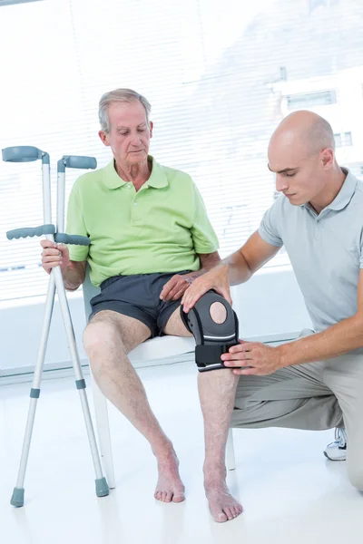 Doctor examining his patient knee — Stock Photo, Image