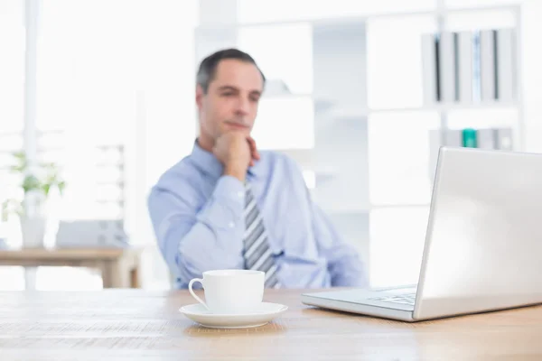 Pensant homme d'affaires sur son bureau — Photo