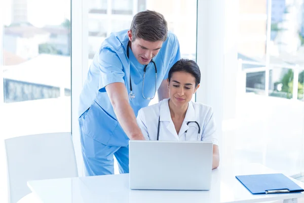 Team van artsen die werkzaam zijn op laptop — Stockfoto