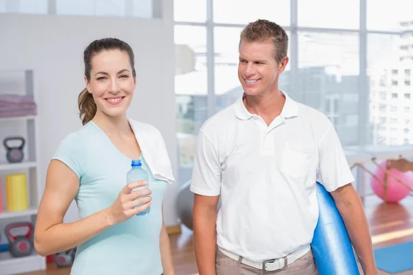 Lächelnde Frau mit ihrem Trainer, der in die Kamera blickt — Stockfoto