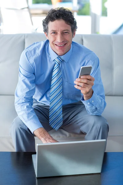 Uomo d'affari che utilizza laptop e telefono — Foto Stock