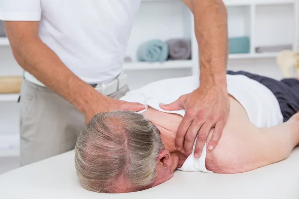 Fisioterapista che fa massaggi alle spalle al paziente — Foto Stock