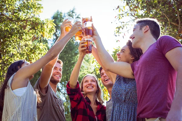 Amigos felices en el parque tomando cervezas — Foto de Stock