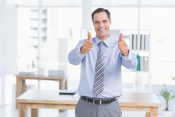 Empresário sorrindo para a câmera com os polegares para cima — Fotografia de Stock