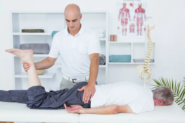 Fysiotherapeut doen been massage aan zijn patiënt — Stockfoto