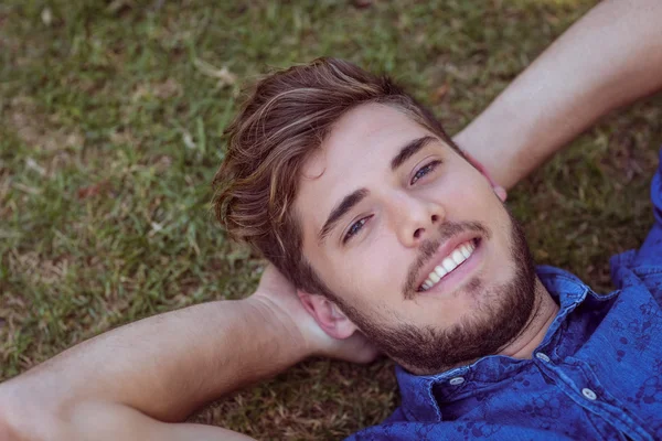 Jonge man liggen in het park — Stockfoto