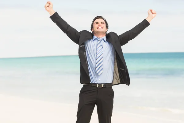 Happy businessman cheering at the beach — 图库照片