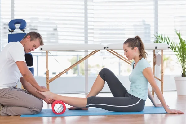 Treinador trabalhando com mulher no tapete de exercício — Fotografia de Stock