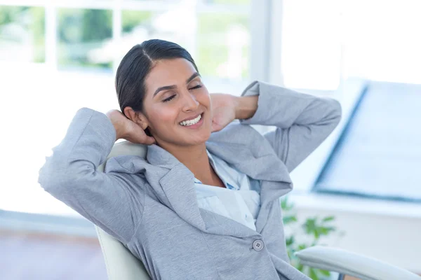 Businesswoman relaxing in a swivel chair — Stock Photo, Image