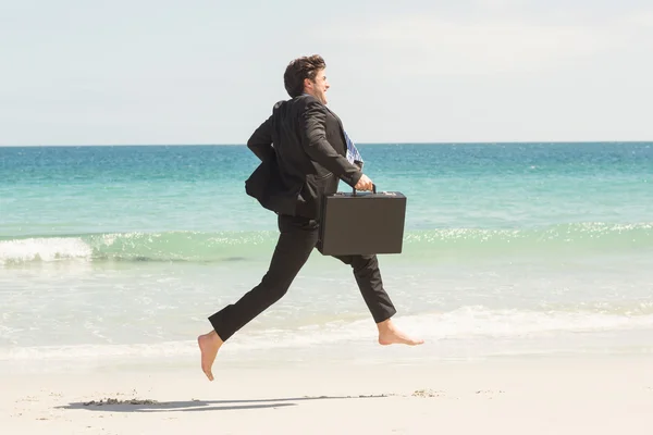 Businessman jumping in front of the sea — Stock Photo, Image