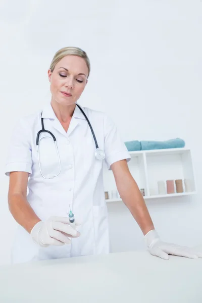 Médico mostrando seringa para câmera — Fotografia de Stock