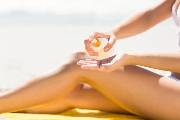 Close up view of Pretty blonde woman putting sun tan lotion on h — Stok fotoğraf